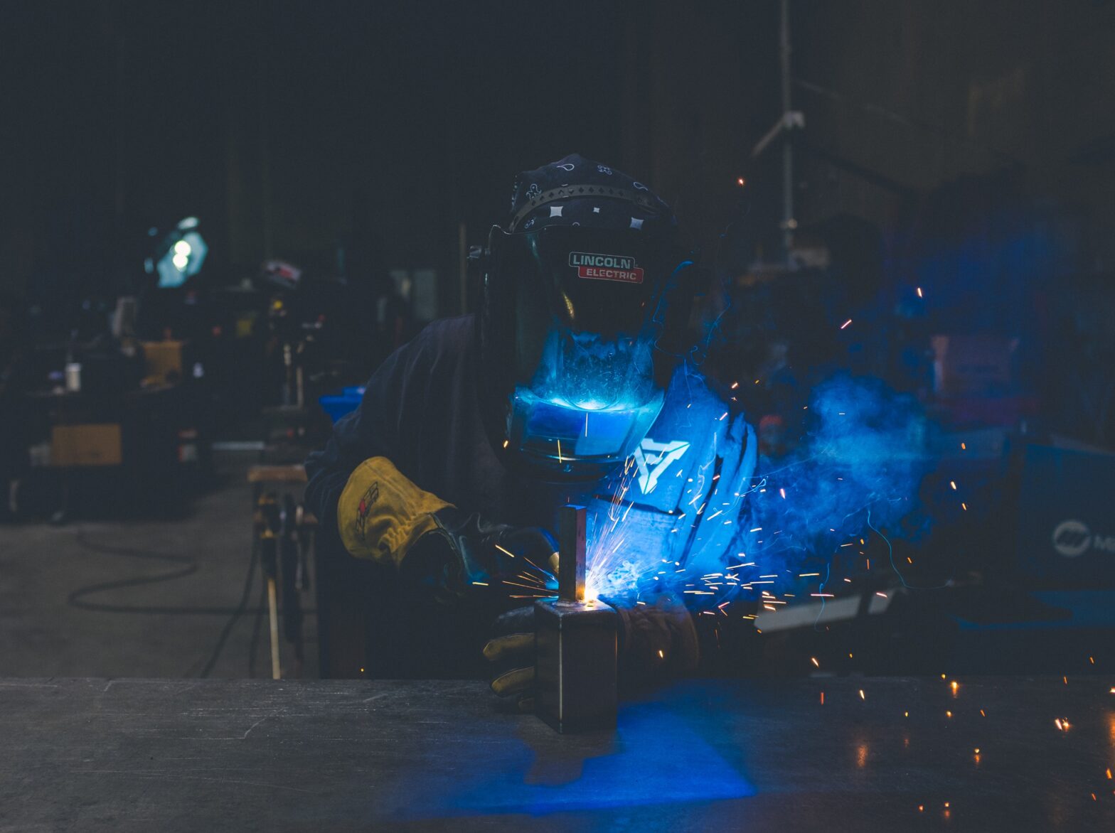 An image of a person welding, wearing PPE