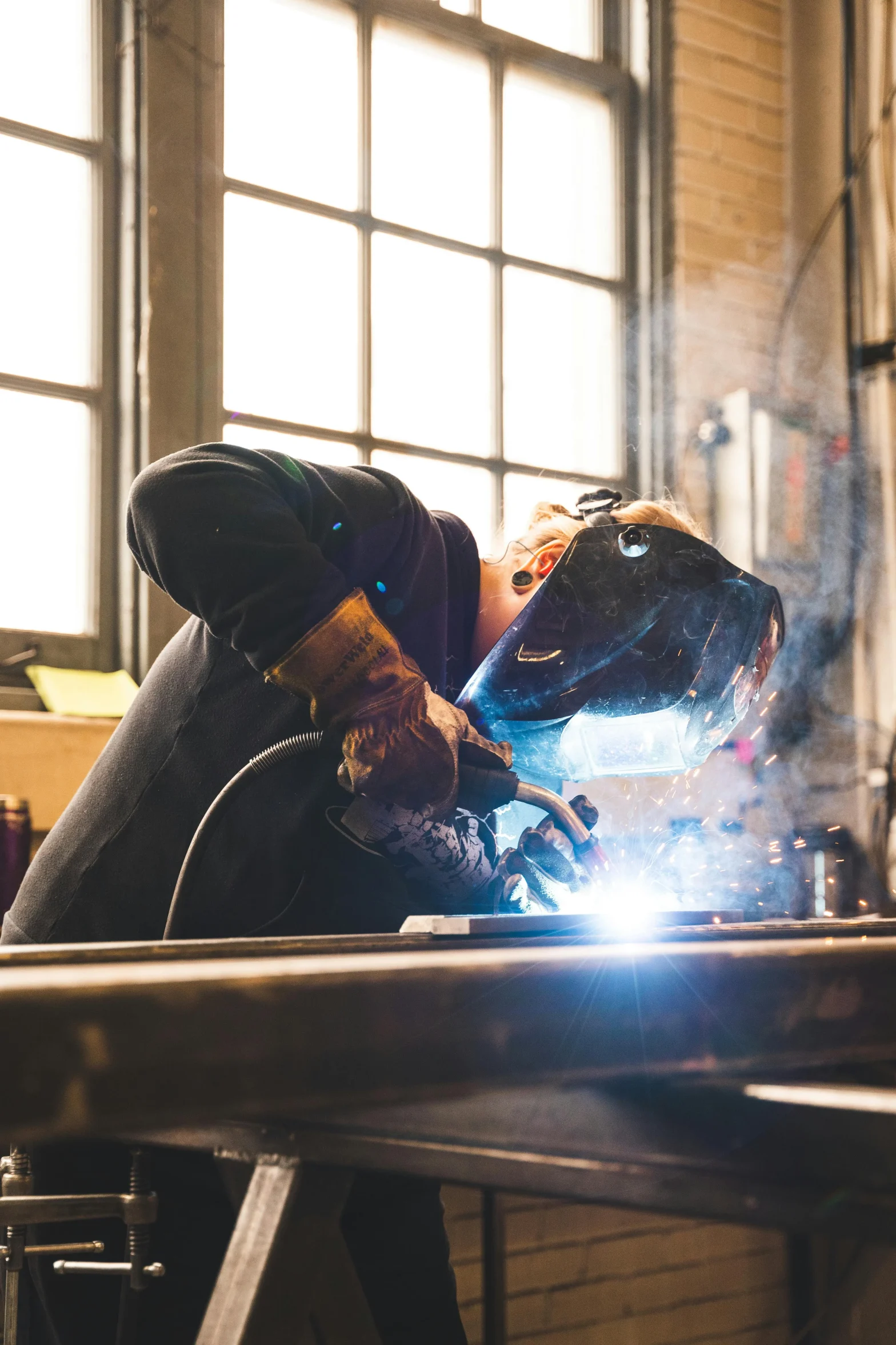 Welder wearing PPE at work station.